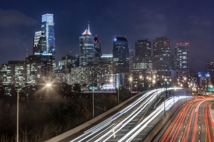 El horizonte de Filadelfia durante la noche, con la autopista Schuylkill en primer plano