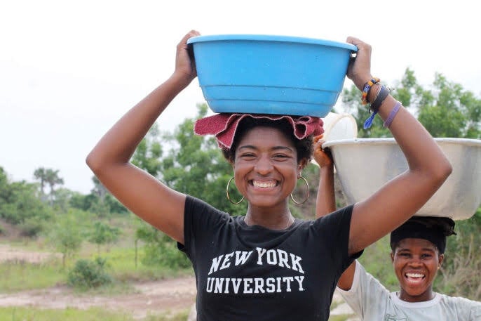 Voluntario en Ghana cargando agua en la cabeza