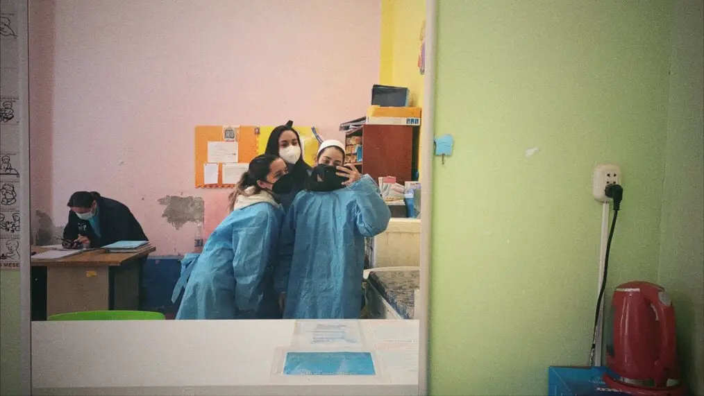 3 Volunteers in medical ponchos taking a photo